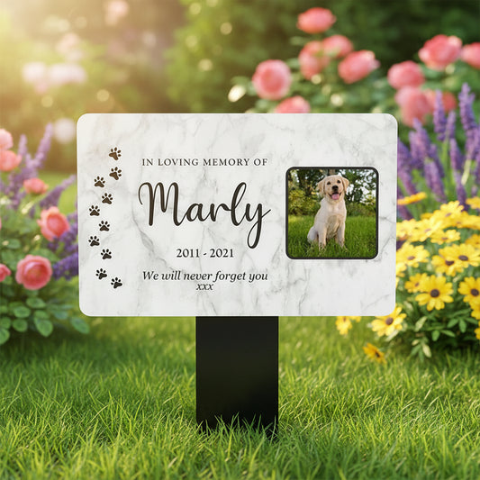 Memorial plaque for a dog named Marly with paw prints and a photo of a dog on a marble background.